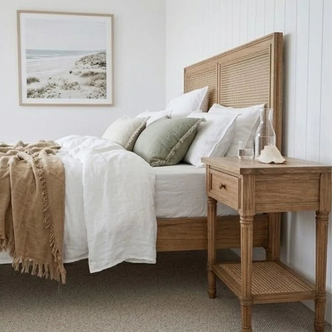 Bedroom with wooden bed and nightstand, white bedding, and a framed picture on the wall.