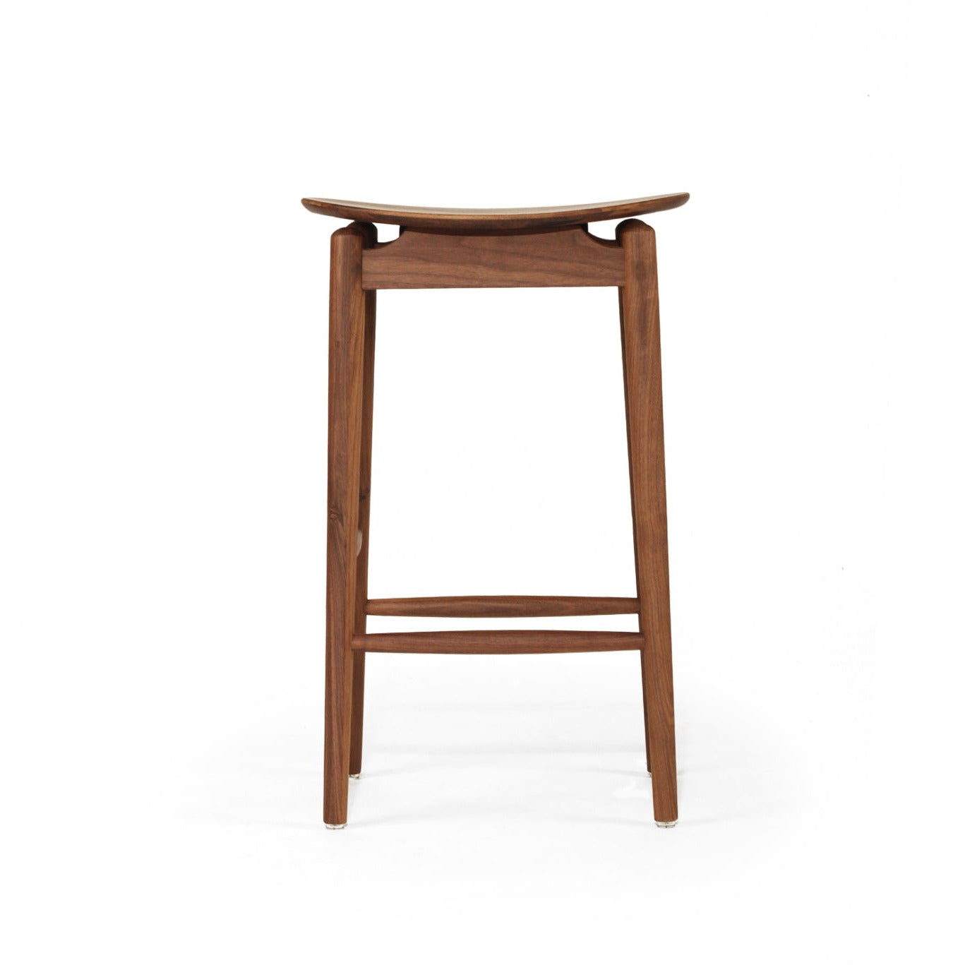 A mid-century modern wooden stool with a curved seat, four legs, and a footrest, shown from the front on a white background.