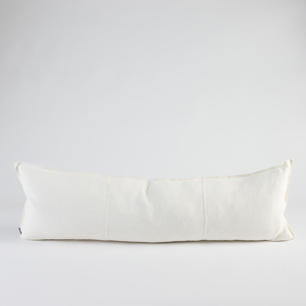 A long, rectangular lumbar pillow in off-white linen fabric, photographed against a seamless light gray studio background.