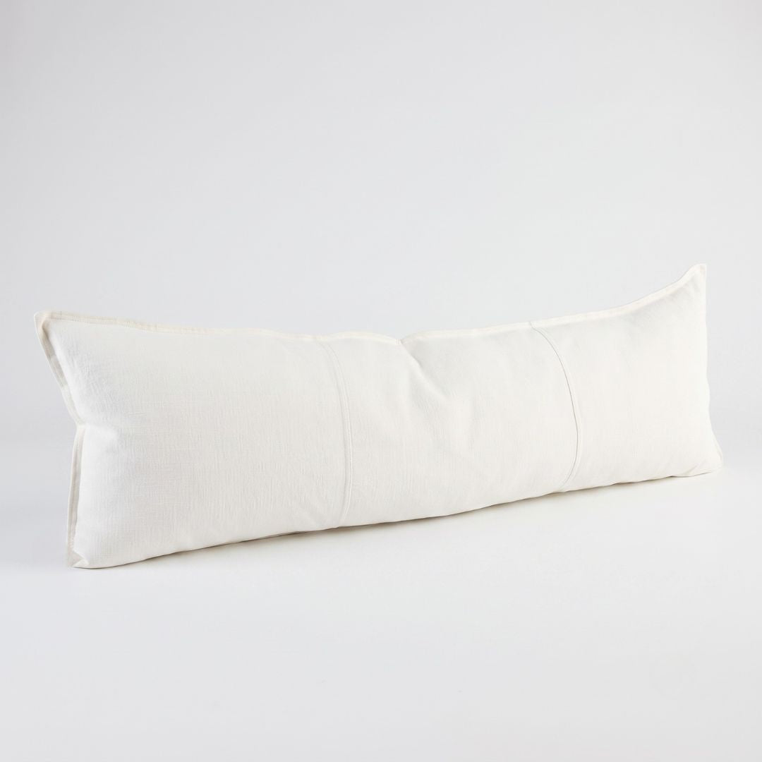 A long, rectangular lumbar pillow in an off-white linen fabric, photographed on a seamless light gray studio background.
