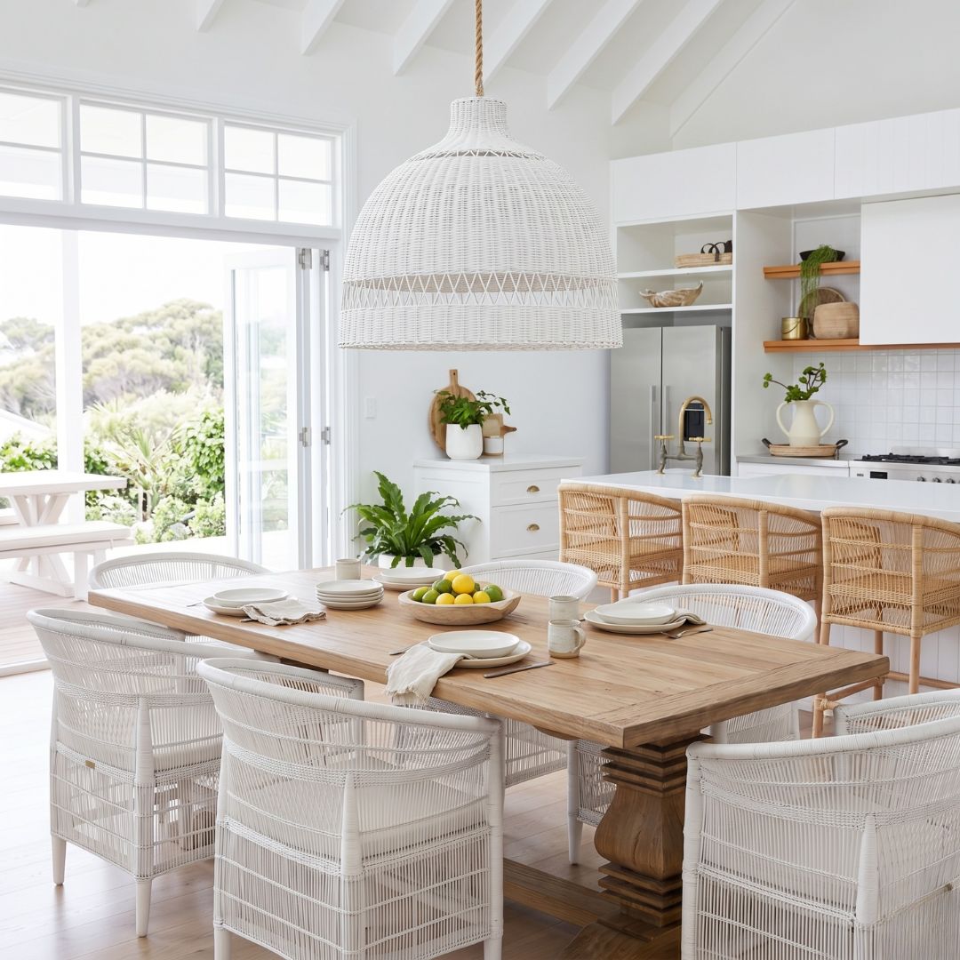Dining area with wooden table and white chairs in a bright kitchen.