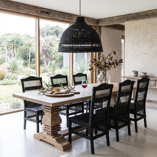 Dining room with wooden table and black chairs, large windows, and outdoor view.