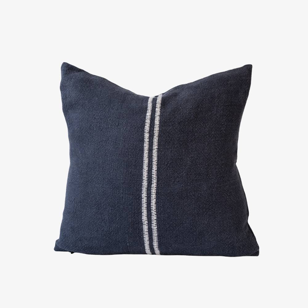 Navy blue pillow with a white stripe on a light gray background