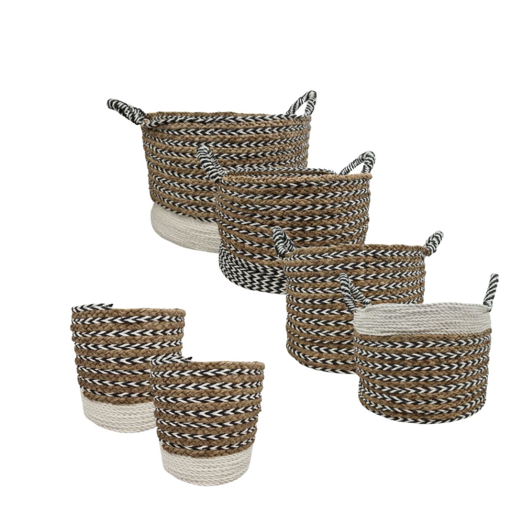Six woven storage baskets in assorted sizes, featuring a braided pattern of brown, black, and off-white, with two baskets finished in solid off-white at the base. Two baskets have integrated handles, and four have loop handles.