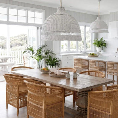 Dining area with wooden table and chairs, white pendant lights, and large windows.
