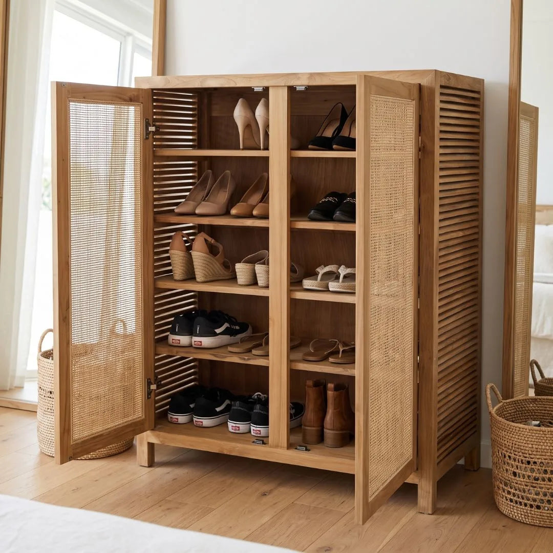 A tall wooden shoe cabinet with two open doors and woven cane panels, filled with various shoes, in a bright room with a wooden floor and window.