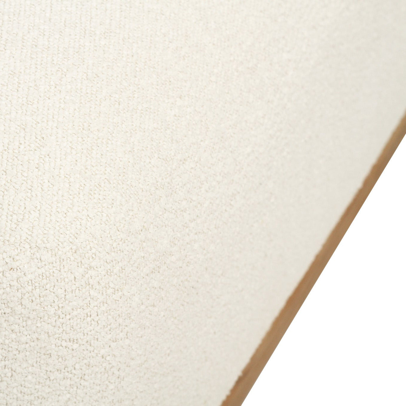 A close-up of a textured off-white fabric or material surface with a tan edge visible against a white background.