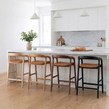 Four bar stools with different finishes in a kitchen setting.