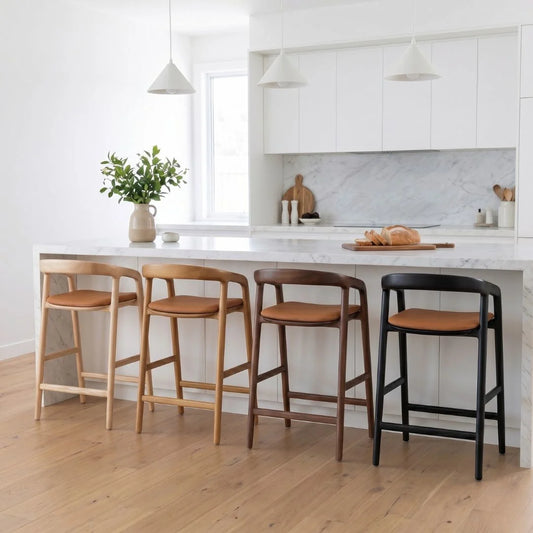 Four bar stools with different finishes in a kitchen setting.