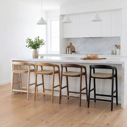 Four bar stools in different colors in a kitchen setting.