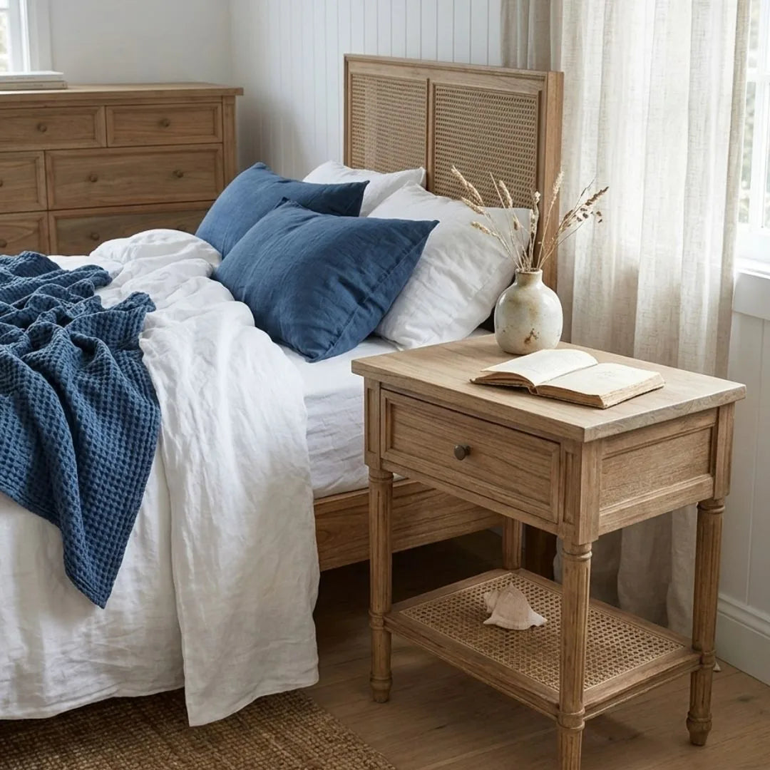 Bedroom with wooden bed and nightstand, featuring blue and white bedding.