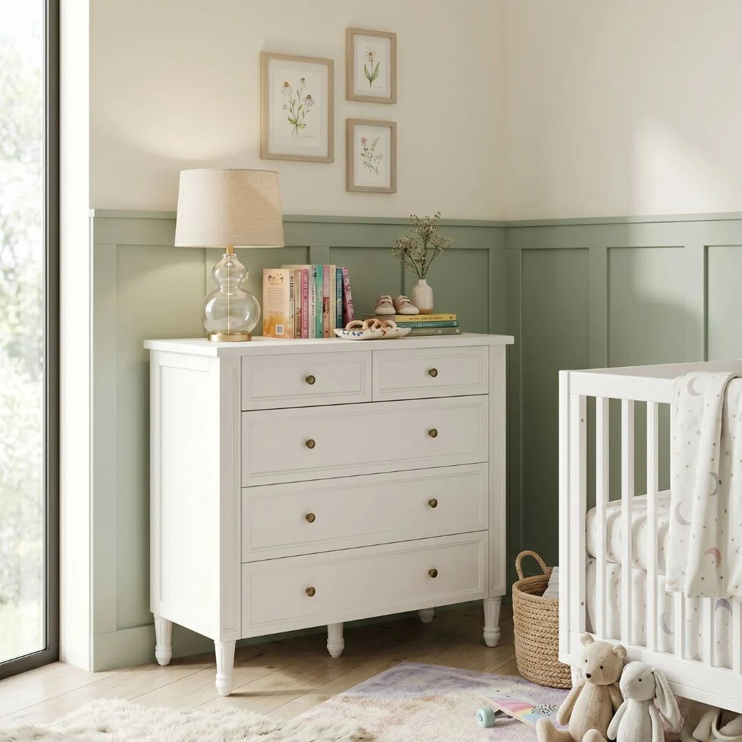 Nursery room with a white dresser and crib.