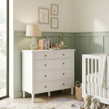 Nursery room with a white dresser and crib.