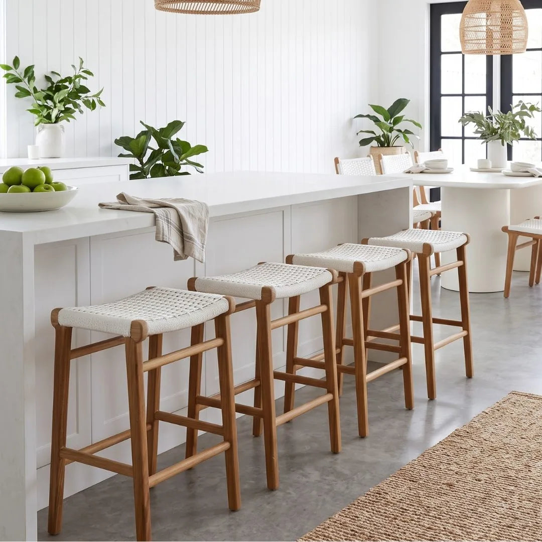Wooden bar stools with white seats in a modern kitchen setting.