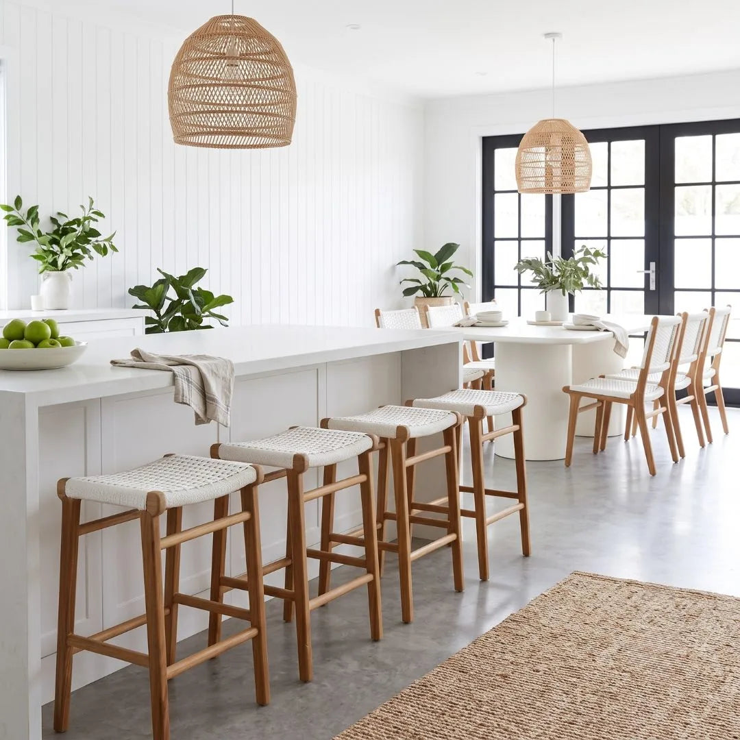 Modern kitchen with white island, bar stools, and pendant lights.