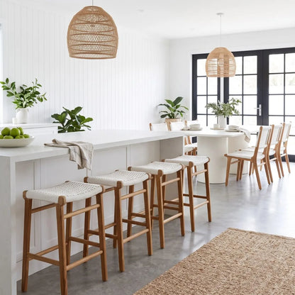 Modern kitchen with white island, bar stools, and pendant lights.