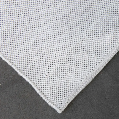 Close-up of a textured off white eco floor mat on a dark background