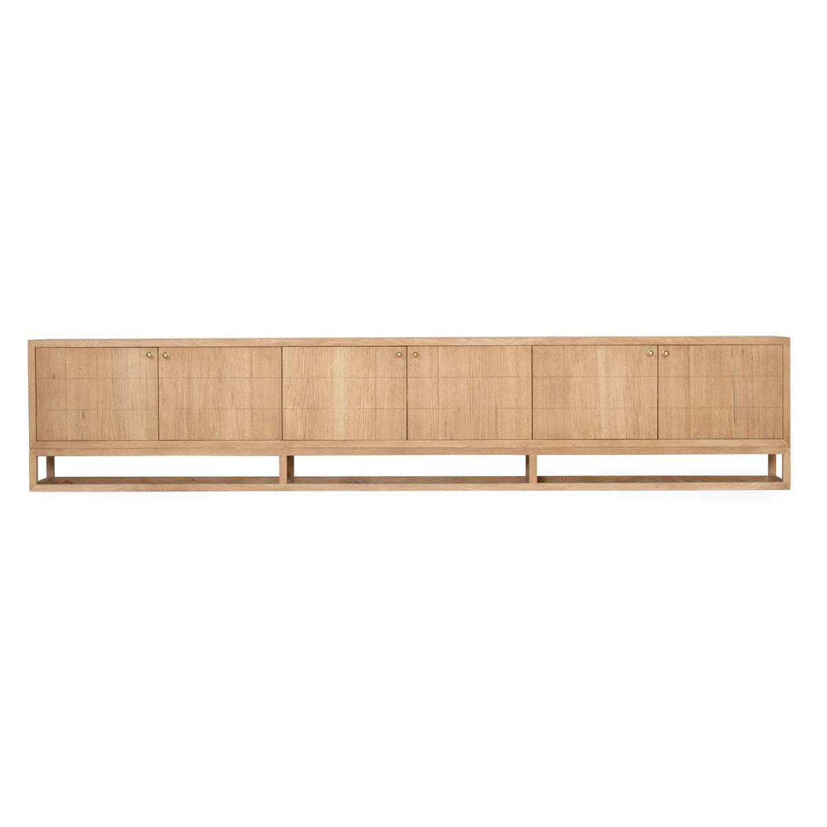 A long, low wooden sideboard or credenza with six cabinet doors, shown in a light natural oak finish against a plain white background.