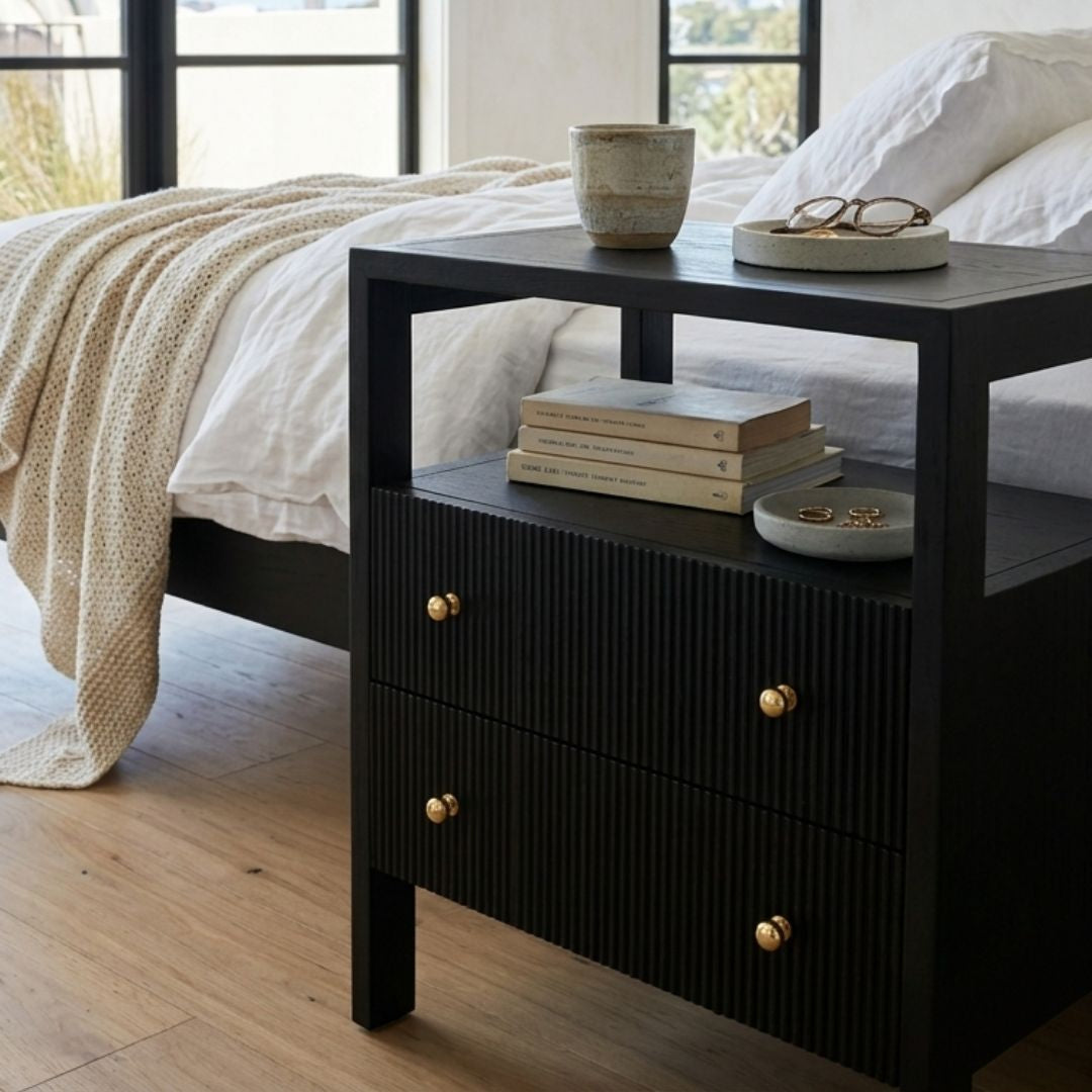 Black bedside table in a coastal bedroom setting