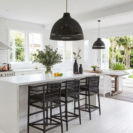 Modern kitchen with white island, black bar stools, and decorative elements.