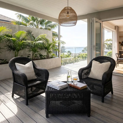 Outdoor patio with wicker chairs, table, and decor on a wooden deck.