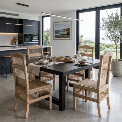 Dining area with a black table and wicker chairs in a modern kitchen.