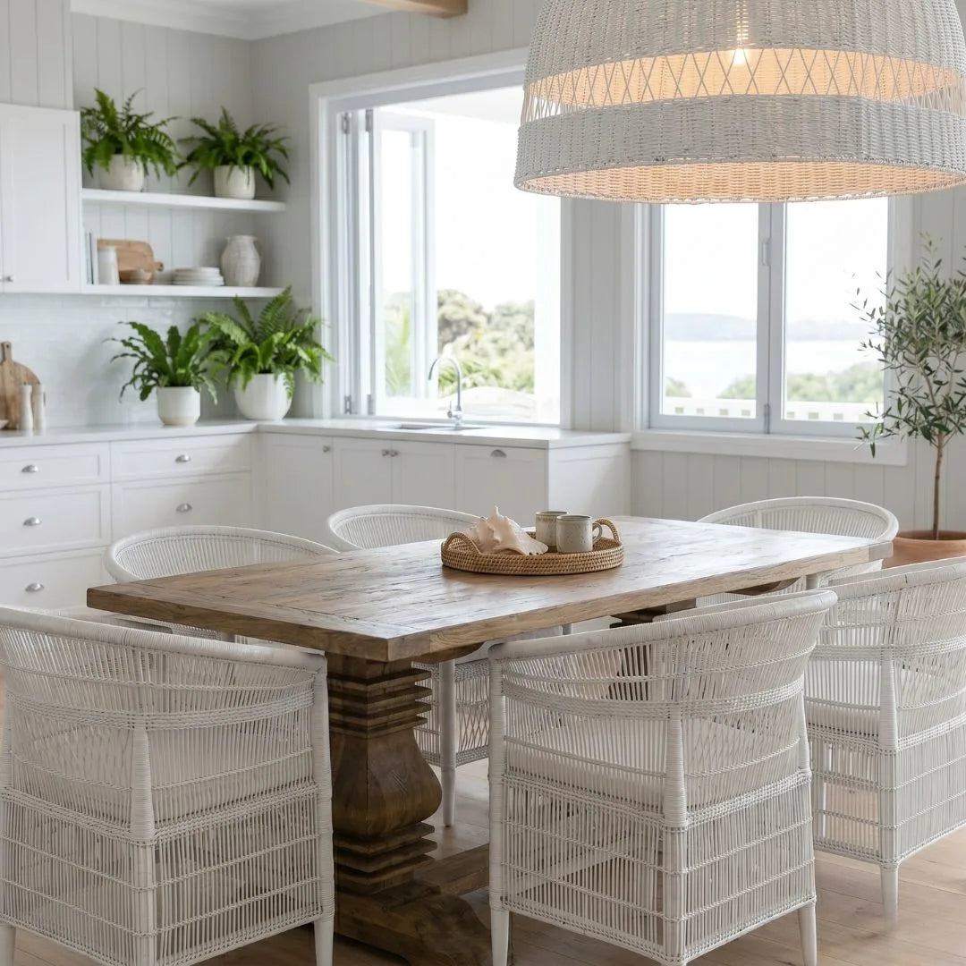 Dining area with wooden table and wicker chairs in a bright room.