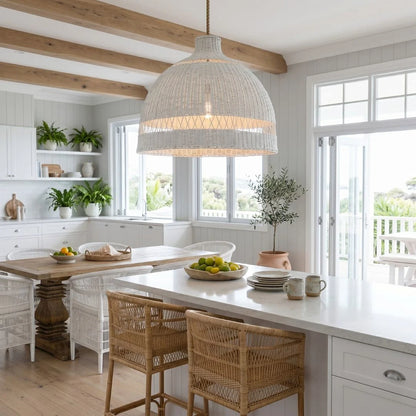Modern kitchen with white countertops, wooden dining table, and wicker chairs.