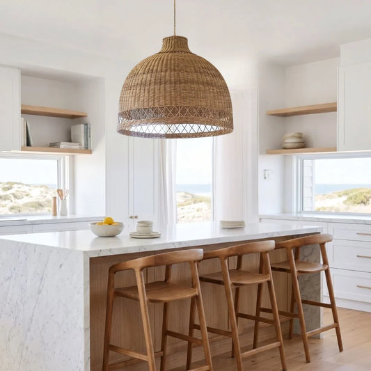 Modern kitchen with a bar area, oversized cane pendant light, and wooden stools.