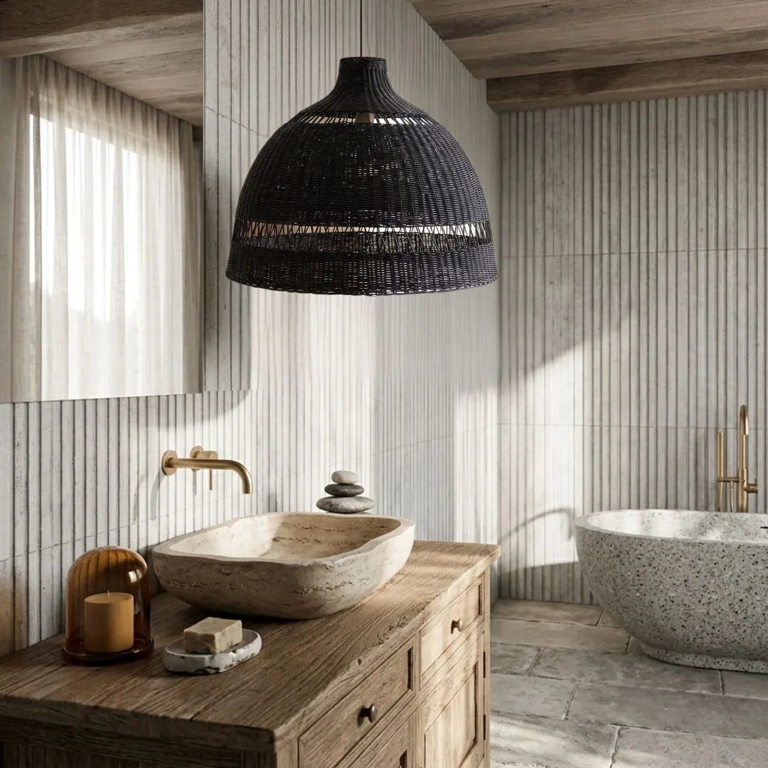 Bathroom interior with wooden vanity, black pendant light, and stone bathtub.
