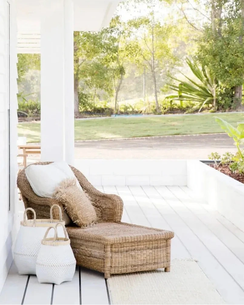 Woven Cane Malawi sunlounge with cushions on a white deck with a view of greenery outside