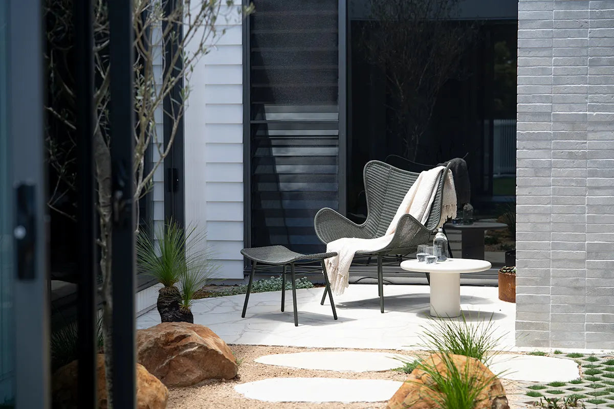 Modern outdoor seating area with a chair and small table on a patio.