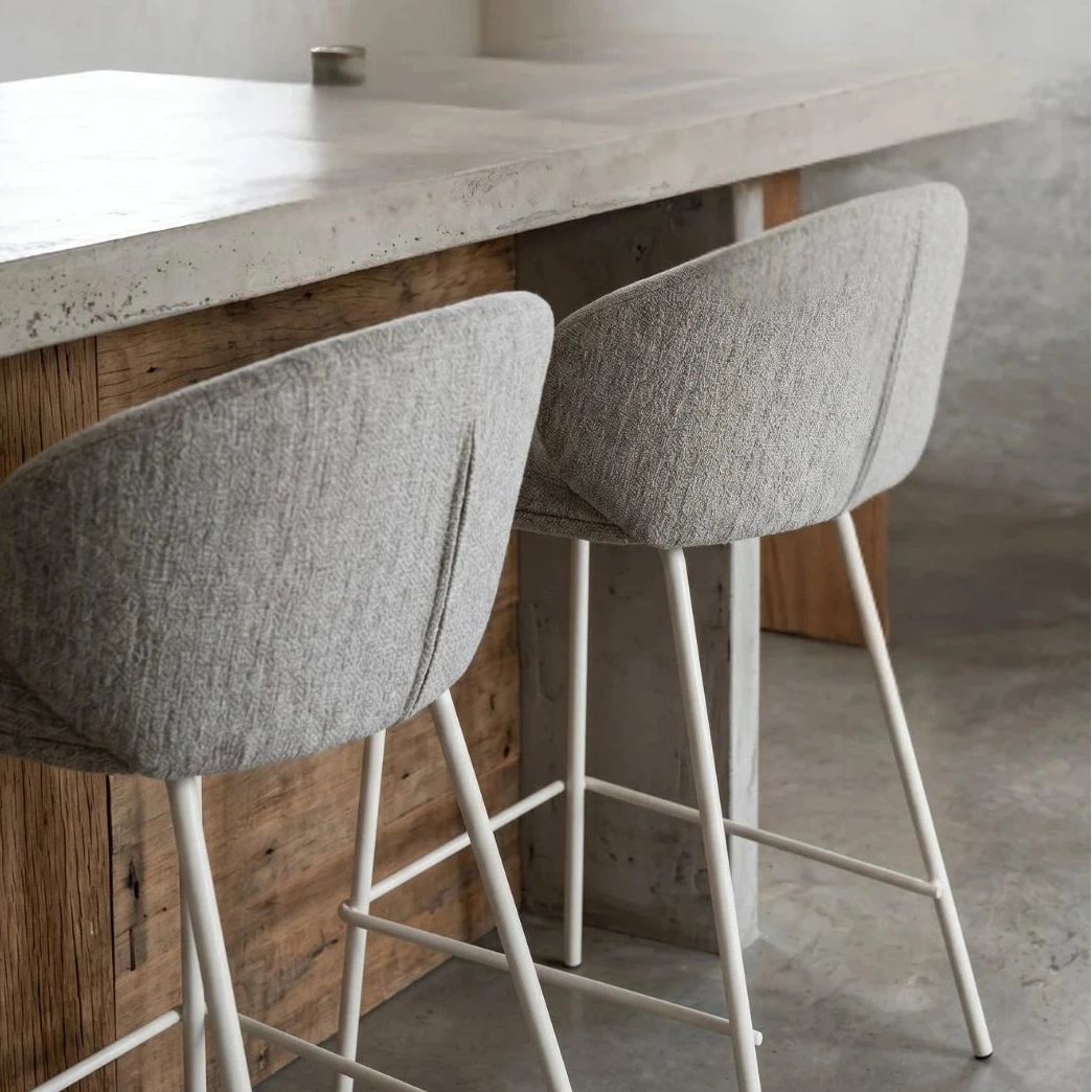 Two gray bar stools with white legs in front of a wooden counter.