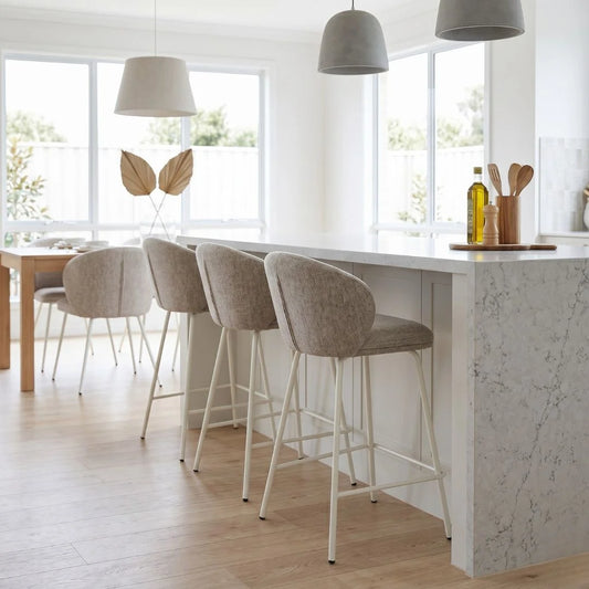 Modern kitchen with marble island, bar stools, and pendant lights.