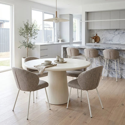 Modern kitchen with round dining table and chairs, marble countertop, and large windows.