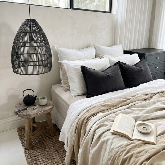 Neatly made bed with white and gray bedding in a bedroom setting.