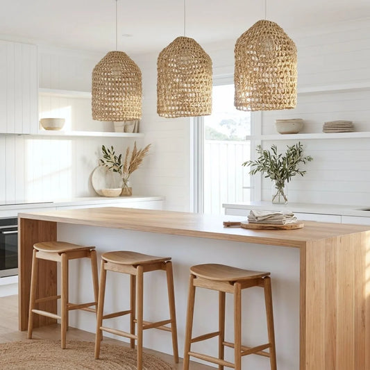 Modern kitchen with wooden island, stools, and wicker pendant lights.