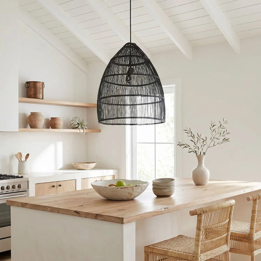 Modern kitchen with wooden island, pendant light, and wicker chairs.