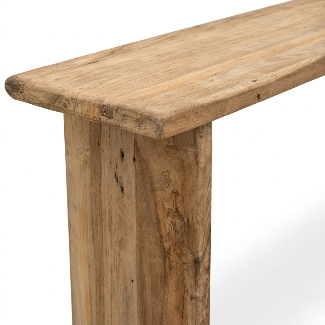 Close-up of a rustic wooden table with a thick, rounded top and a sturdy post leg, showcasing natural wood grain and knots on a white background.