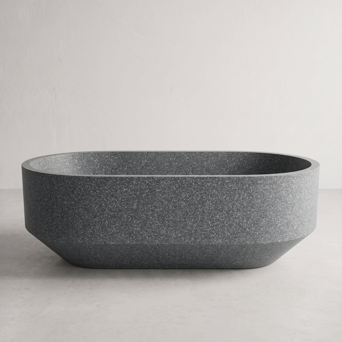 A dark gray freestanding bathtub with a textured, speckled finish, shown against a neutral light gray background.