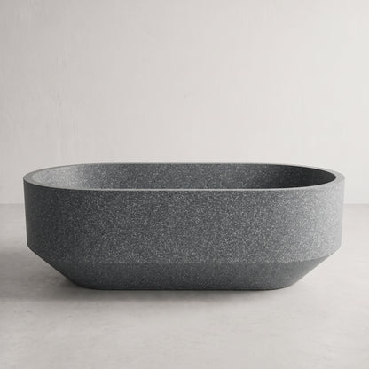 A dark gray freestanding bathtub with a textured, speckled finish, shown against a neutral light gray background.