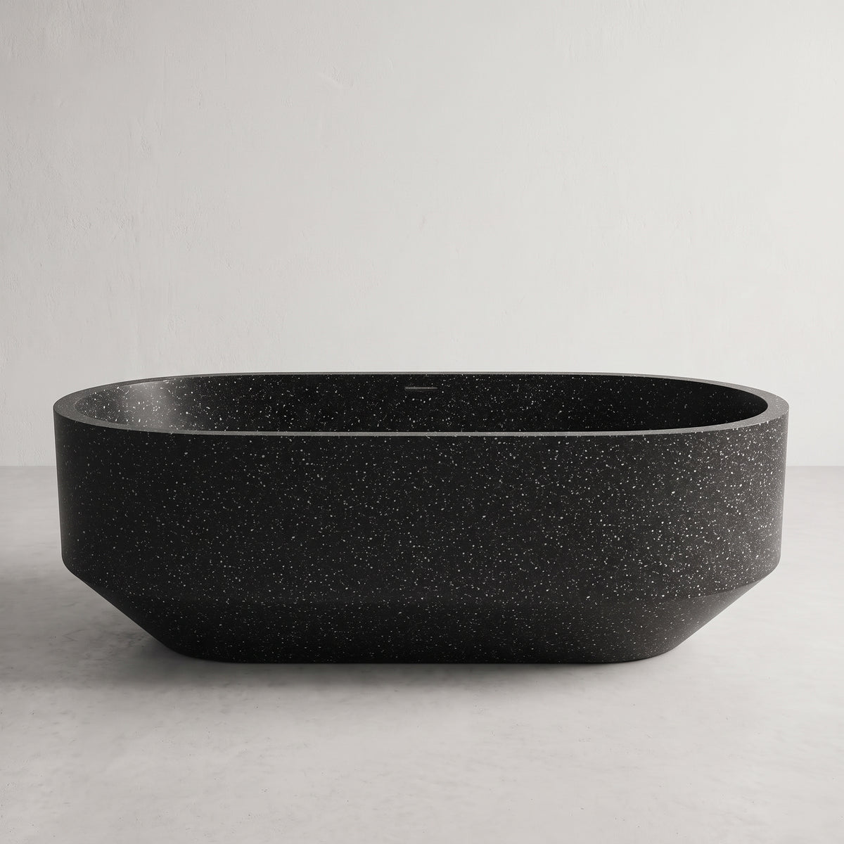A matte black freestanding bathtub with a subtle white speckled texture, shown against a neutral light gray background.