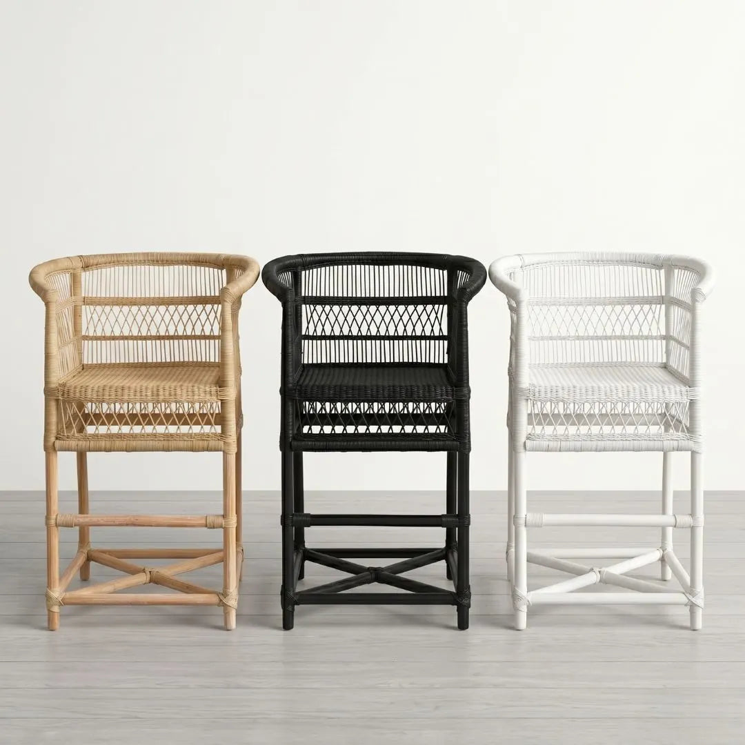 Three wicker chairs in natural, black, and white on a light wooden floor.