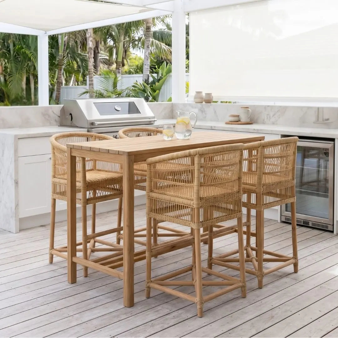 Outdoor kitchen with wooden dining table and chairs on a deck