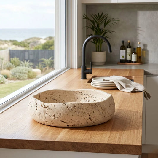Travertine bowl on a wooden countertop with a modern kitchen setting