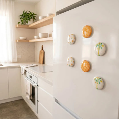Modern kitchen with white cabinets, a refrigerator, and decorative fridge magnets.