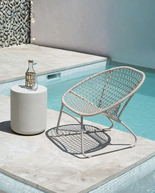 Woven chair and round table by a poolside