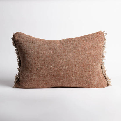 Brown textured pillow with frayed edges on a white background