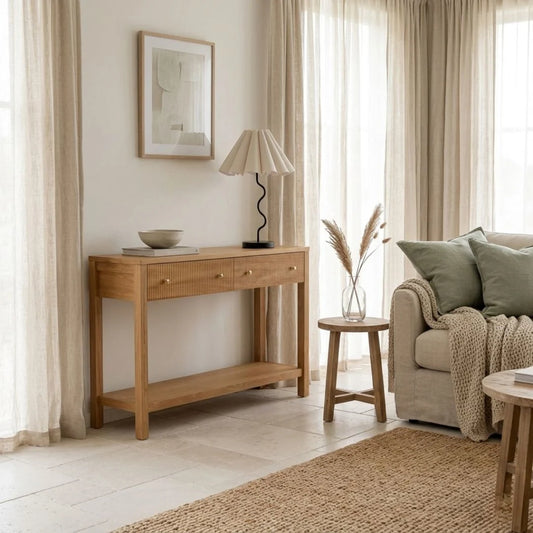 Living room with wooden console table, lamp, and sofa with pillows.