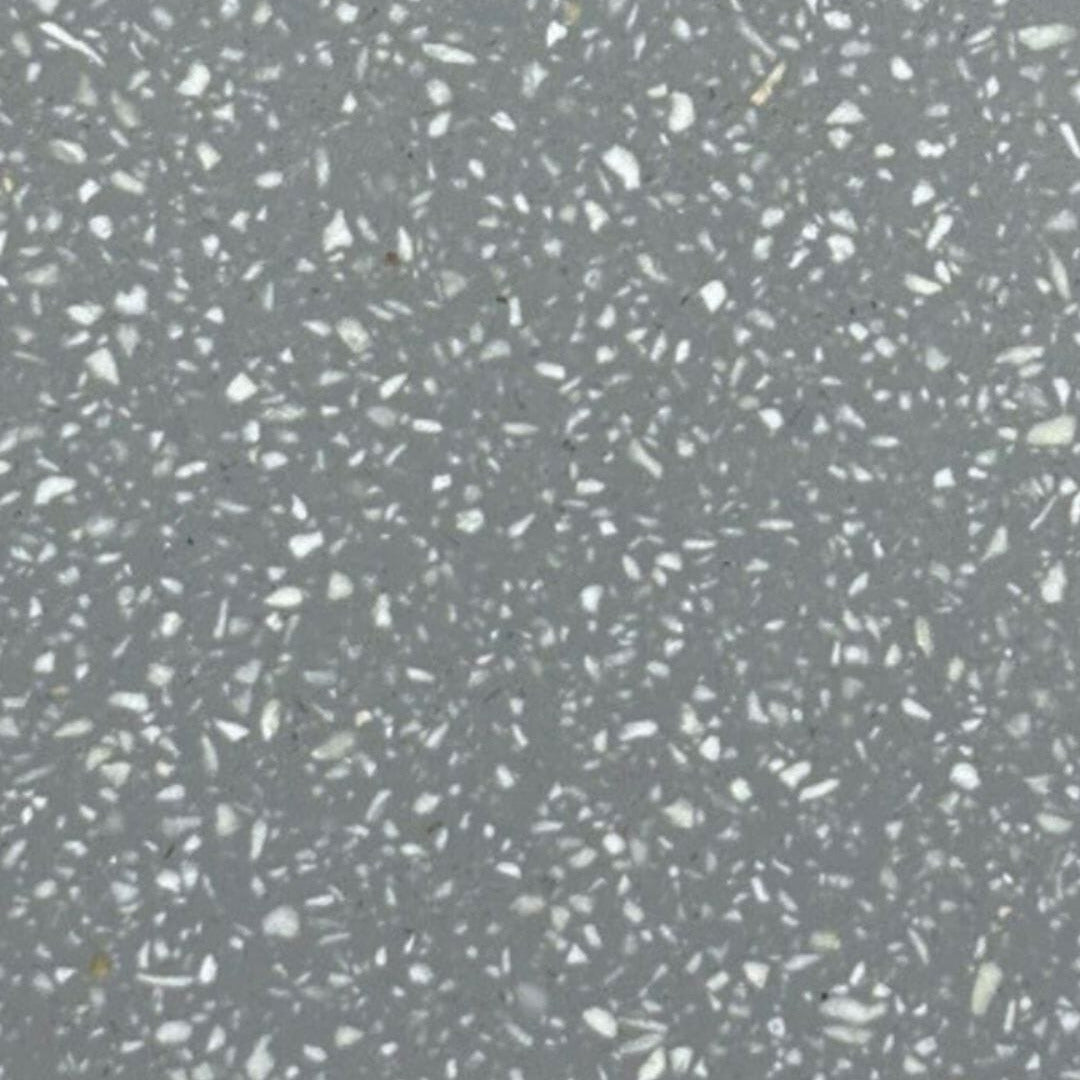 A close-up of a gray terrazzo or concrete-like surface with scattered white and light gray flecks throughout.